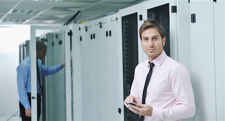 fast internet - young business man computer science engeneer talking by cellphone at network datacenter server room asking  for help and fast solutions and services Stock Photo - Budget Royalty-Free & Subscription, Code: 400-05728680