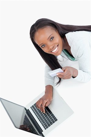 Smiling woman entering credit card information against a white background Stock Photo - Budget Royalty-Free & Subscription, Code: 400-05729194