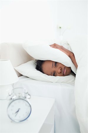 simsearch:6109-06194408,k - Portrait of a sad woman covering her ears while her alarm clock is ringing in her bedroom Stockbilder - Microstock & Abonnement, Bildnummer: 400-05729386