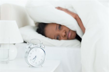 simsearch:6109-06194402,k - Young woman covering her ears while her alarm clock is ringing with the camera focus on the object Stock Photo - Budget Royalty-Free & Subscription, Code: 400-05729380
