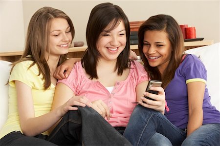 simsearch:6109-06003316,k - Teenage Girlfriends Reading Mobile Phone at Home Fotografie stock - Microstock e Abbonamento, Codice: 400-05729905