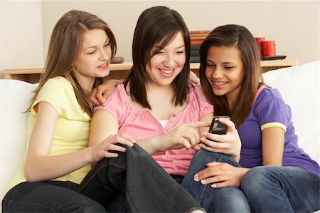 simsearch:6109-06003316,k - Teenage Girlfriends Reading Mobile Phone at Home Fotografie stock - Microstock e Abbonamento, Codice: 400-05729906