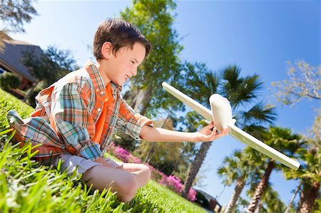 polystyrène - A young boy sitting on grass outside playing with a toy model airplane Foto de stock - Super Valor sin royalties y Suscripción, Código: 400-05721417