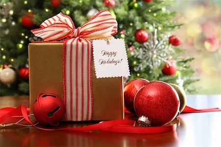 simsearch:400-04199939,k - Christmas gift sitting on a table with a tree in the background Stock Photo - Budget Royalty-Free & Subscription, Code: 400-05722856