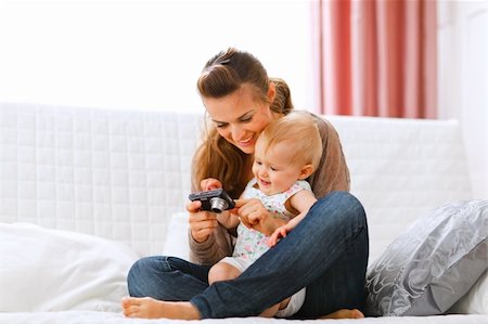 simsearch:400-05750410,k - Young mother and smiling baby looking photos in camera at home Photographie de stock - Aubaine LD & Abonnement, Code: 400-05723087