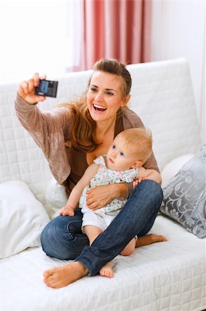 simsearch:400-05899075,k - Beautiful young mom making photos with her lovely baby at home Fotografie stock - Microstock e Abbonamento, Codice: 400-05723089