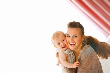 simsearch:400-05899075,k - Portrait of happy young mother with her smiling baby at home Fotografie stock - Microstock e Abbonamento, Codice: 400-05723082