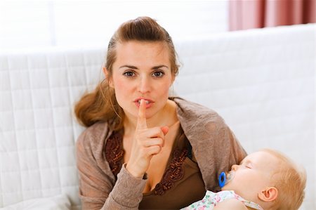 simsearch:400-05750410,k - Young mama holding sleeping baby and showing shh gesture at home Photographie de stock - Aubaine LD & Abonnement, Code: 400-05723092