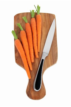 person chopping carrots - Baby carrot vegetables  on an olive wood chopping board with stainless steel kitchen knife over white background. Stock Photo - Budget Royalty-Free & Subscription, Code: 400-05734323