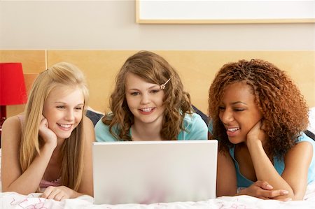 Group Of Three Teenage Girls Using Laptop In Bedroom Foto de stock - Super Valor sin royalties y Suscripción, Código: 400-05734756