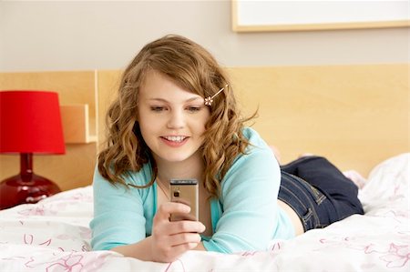 simsearch:400-06105120,k - Teenage Girl In Bedroom With Mobile Phone Fotografie stock - Microstock e Abbonamento, Codice: 400-05734780