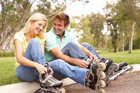 Couple Putting On In Line Skates In Park Stock Photo - Budget Royalty-Free & Subscription, Code: 400-05736208