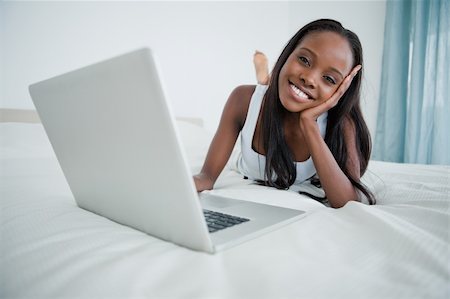 simsearch:400-05737165,k - Woman watching a movie on her laptop in her bedroom Stock Photo - Budget Royalty-Free & Subscription, Code: 400-05737222