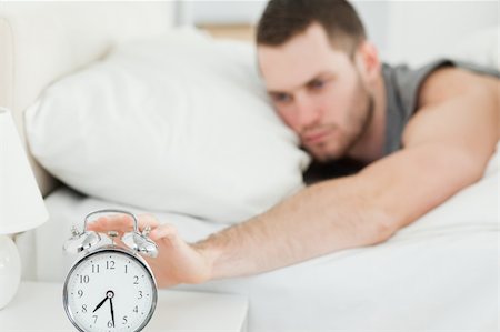 simsearch:400-04335052,k - Tired man switching off his alarm clock in his bedroom Foto de stock - Super Valor sin royalties y Suscripción, Código: 400-05737256