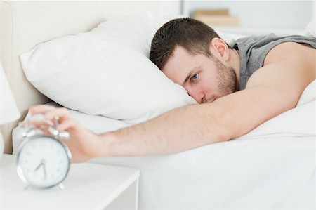 simsearch:400-04335052,k - Handsome man being awakened by an alarm clock in his bedroom Foto de stock - Super Valor sin royalties y Suscripción, Código: 400-05737268