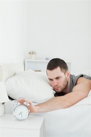 simsearch:400-04335052,k - Portrait of a unhappy man being awakened by an alarm clock in his bedroom Foto de stock - Super Valor sin royalties y Suscripción, Código: 400-05737263