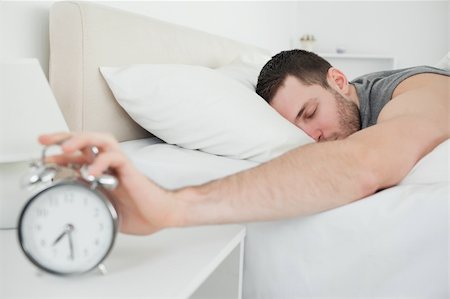 simsearch:400-04335052,k - Sleeping handsome man being awakened by an alarm clock in his bedroom Foto de stock - Super Valor sin royalties y Suscripción, Código: 400-05737272