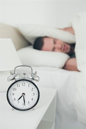 simsearch:700-03554506,k - Portrait of a man covering his ears with a pillow while his alarm clock is ringing Stockbilder - Microstock & Abonnement, Bildnummer: 400-05737295