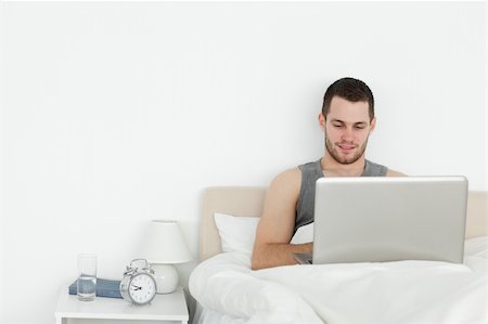 Man using a laptop in his bedroom Stock Photo - Budget Royalty-Free & Subscription, Code: 400-05737436