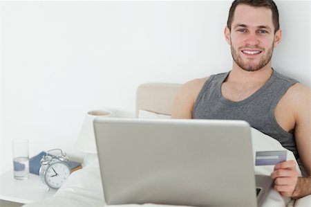 shopaholic (male) - Handsome man shopping online in his bedroom Stock Photo - Budget Royalty-Free & Subscription, Code: 400-05737456