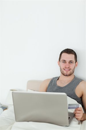 simsearch:400-05742016,k - Portrait of a man shopping online in his bedroom Stock Photo - Budget Royalty-Free & Subscription, Code: 400-05737457
