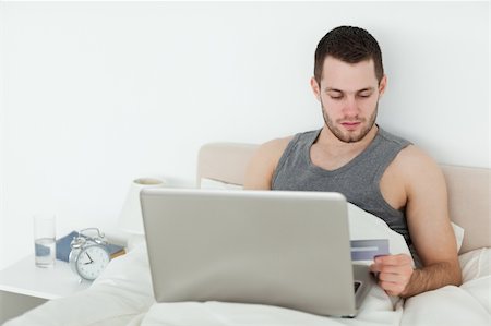 shopaholic (male) - Attractive man shopping online in his bedroom Stock Photo - Budget Royalty-Free & Subscription, Code: 400-05737459