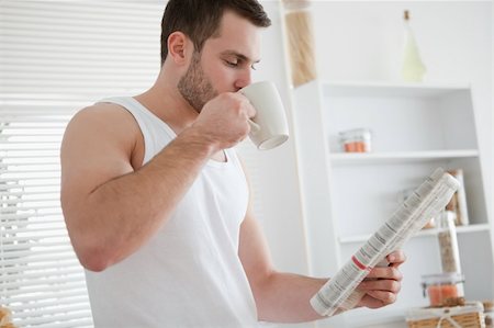 simsearch:400-04335708,k - Young man drinking coffee while reading the news in his kitchen Foto de stock - Super Valor sin royalties y Suscripción, Código: 400-05737575