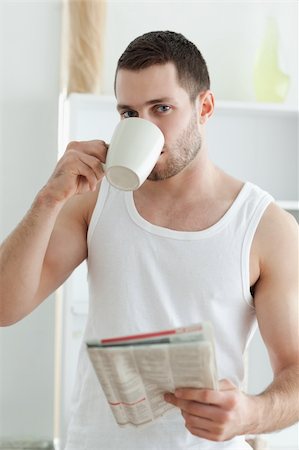 simsearch:400-05737647,k - Portrait of a handsome man drinking tea while reading the news in his kitchen Stock Photo - Budget Royalty-Free & Subscription, Code: 400-05737578