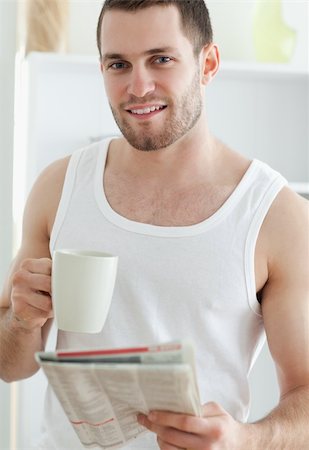simsearch:400-05737647,k - Portrait of a handsome man drinking coffee while reading the news in his kitchen Stock Photo - Budget Royalty-Free & Subscription, Code: 400-05737579
