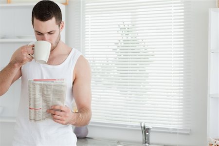 simsearch:400-04335708,k - Man drinking tea while reading the news in his kitchen Foto de stock - Super Valor sin royalties y Suscripción, Código: 400-05737572