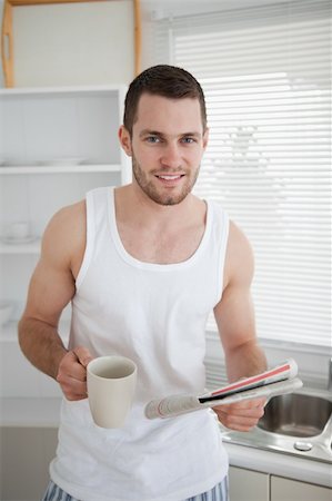 simsearch:400-05737647,k - Portrait of a man drinking coffee while reading the news in his kitchen Stock Photo - Budget Royalty-Free & Subscription, Code: 400-05737573
