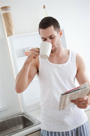 simsearch:400-04335708,k - Portrait of a good looking man drinking tea while reading the news in his kitchen Stockbilder - Microstock & Abonnement, Bildnummer: 400-05737584