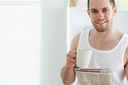simsearch:400-05737647,k - Good looking man drinking tea while reading the news in his kitchen Stock Photo - Budget Royalty-Free & Subscription, Code: 400-05737585