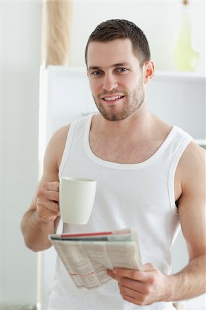 simsearch:400-04335708,k - Portrait of a smiling man drinking coffee while reading the news in his kitchen Foto de stock - Super Valor sin royalties y Suscripción, Código: 400-05737580