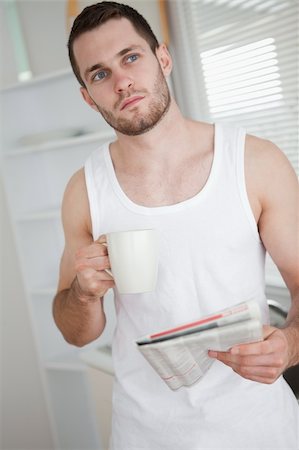 simsearch:400-05737647,k - Portrait of a healthy man drinking tea while reading the news in his kitchen Stock Photo - Budget Royalty-Free & Subscription, Code: 400-05737594