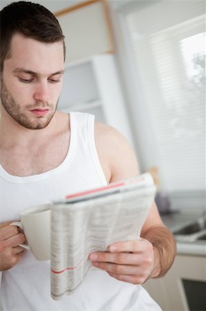 simsearch:400-05737647,k - Portrait of a man drinking orange juice while reading the news in his kitchen Stock Photo - Budget Royalty-Free & Subscription, Code: 400-05737598