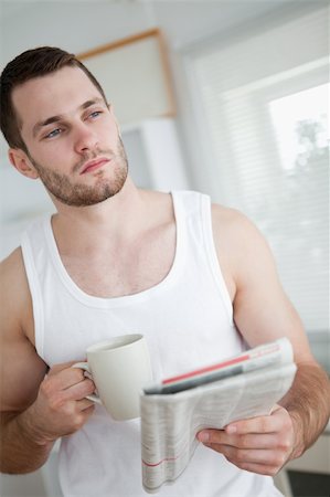 simsearch:400-05737647,k - Portrait of a serious man drinking orange juice while reading the news in his kitchen Stock Photo - Budget Royalty-Free & Subscription, Code: 400-05737601