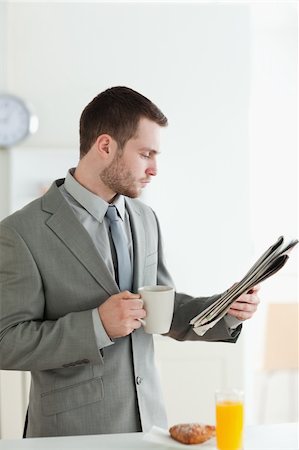 simsearch:400-05737647,k - Portrait of a businessman having breakfast while reading the news in his kitchen Stock Photo - Budget Royalty-Free & Subscription, Code: 400-05737619