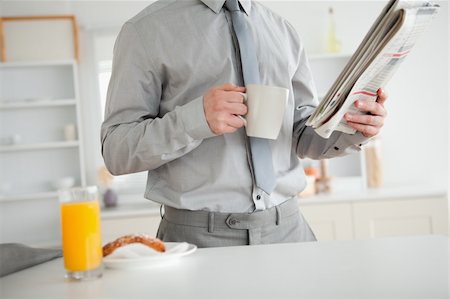 simsearch:400-04335708,k - Businessman holding a newspaper while having breakfast in his kitchen Stockbilder - Microstock & Abonnement, Bildnummer: 400-05737629