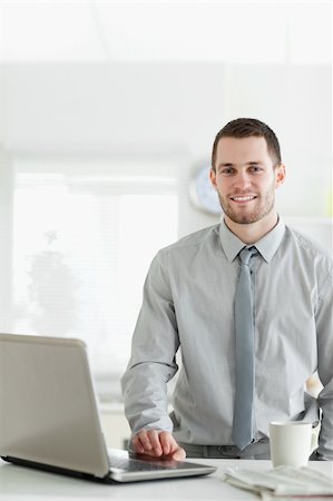 simsearch:400-05737647,k - Portrait of a businessman using a laptop while drinking tea in his kitchen Stock Photo - Budget Royalty-Free & Subscription, Code: 400-05737645