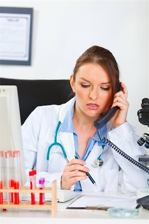 simsearch:400-07099889,k - Doctor woman sitting in office and making phone call Stock Photo - Budget Royalty-Free & Subscription, Code: 400-05739355