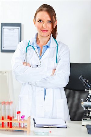 simsearch:400-04390415,k - Portrait of doctor woman with crossed arms standing at office desk Stock Photo - Budget Royalty-Free & Subscription, Code: 400-05739373