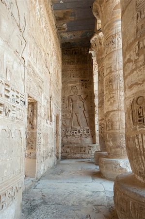 simsearch:400-05739807,k - Egyptian hieroglyphic carvings on a wall at the temple of Medinat Habu in Luxor with columns Foto de stock - Super Valor sin royalties y Suscripción, Código: 400-05739654