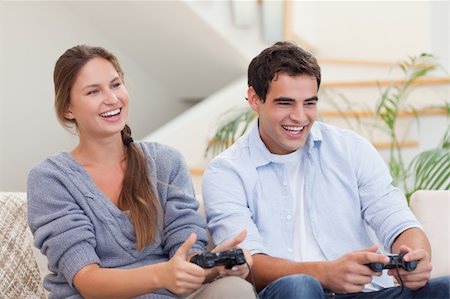 simsearch:400-05740058,k - Smiling couple playing video games in their living room Photographie de stock - Aubaine LD & Abonnement, Code: 400-05739966