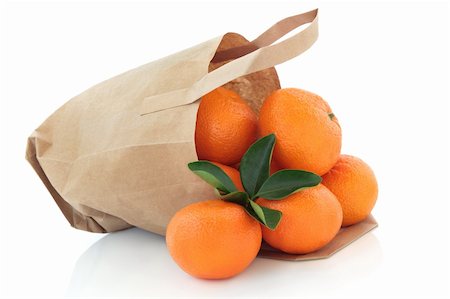 Mandarin orange fruit in a brown paper recycled carrier bag with leaf sprig isolated over white background. Stock Photo - Budget Royalty-Free & Subscription, Code: 400-05730185
