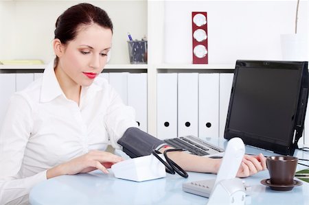 Beautiful caucasian businesswoman measuring her blood pressure in the office. Stock Photo - Budget Royalty-Free & Subscription, Code: 400-05732704