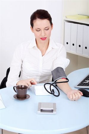 Beautiful caucasian businesswoman measuring her blood pressure in the office. Stock Photo - Budget Royalty-Free & Subscription, Code: 400-05732702