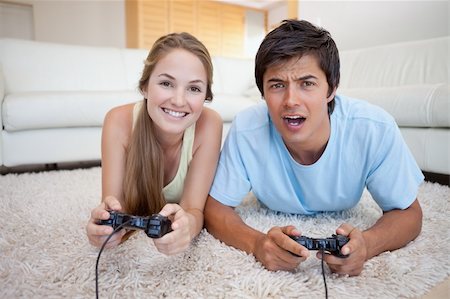 simsearch:400-04878558,k - Playful couple playing video games in their living room Stock Photo - Budget Royalty-Free & Subscription, Code: 400-05746744