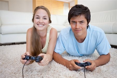 simsearch:400-04878558,k - Cheerful couple playing video games in their living room Stock Photo - Budget Royalty-Free & Subscription, Code: 400-05746745