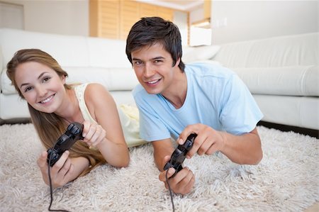 Happy couple playing video games in their living room Stock Photo - Budget Royalty-Free & Subscription, Code: 400-05746746
